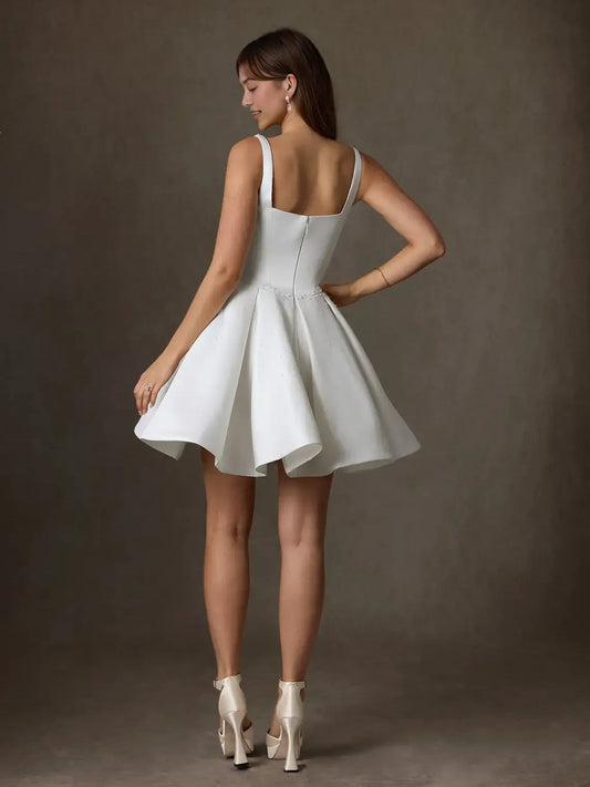 White satin A-line mini wedding dress with pleated skirt and spaghetti straps