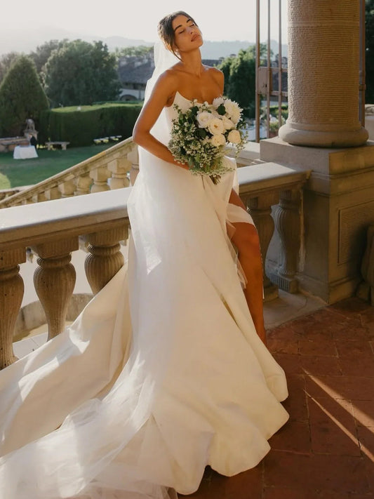 White satin sweetheart A-line wedding dress with draped bodice and side slit
