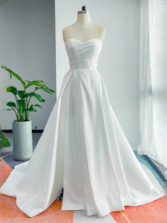 White strapless sweetheart A-line satin wedding dress with fitted bodice and flowing skirt
