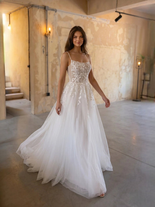 Ivory floral lace bodice A-line tulle wedding dress with thin straps, full skirt, floor-length.