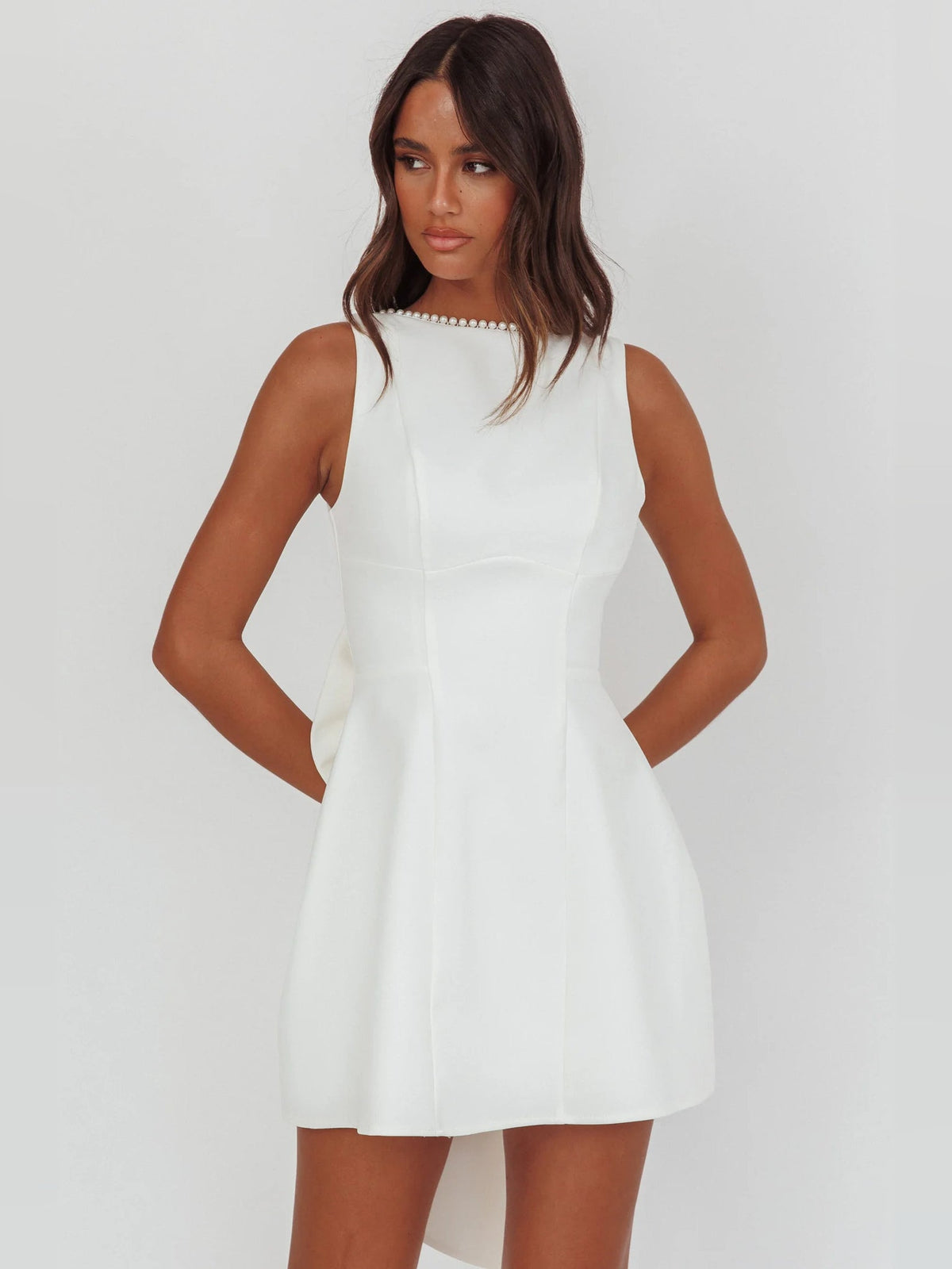 White sleeveless mini dress with pearl-trim high neckline and A-line skirt