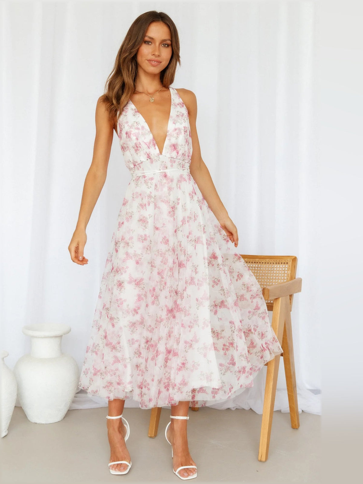 Pink floral midi dress with deep V-neck and spaghetti straps, tiered skirt