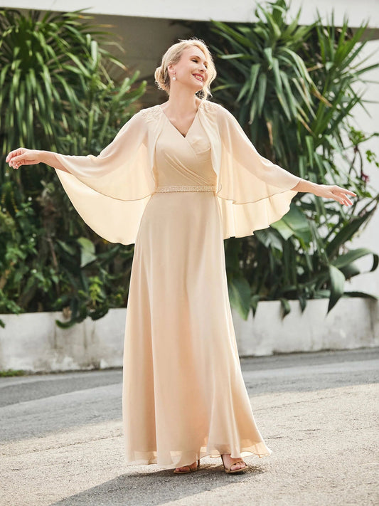 Champagne chiffon A-line dress with V-neck, beaded waist, flowing cape sleeves, floor length.