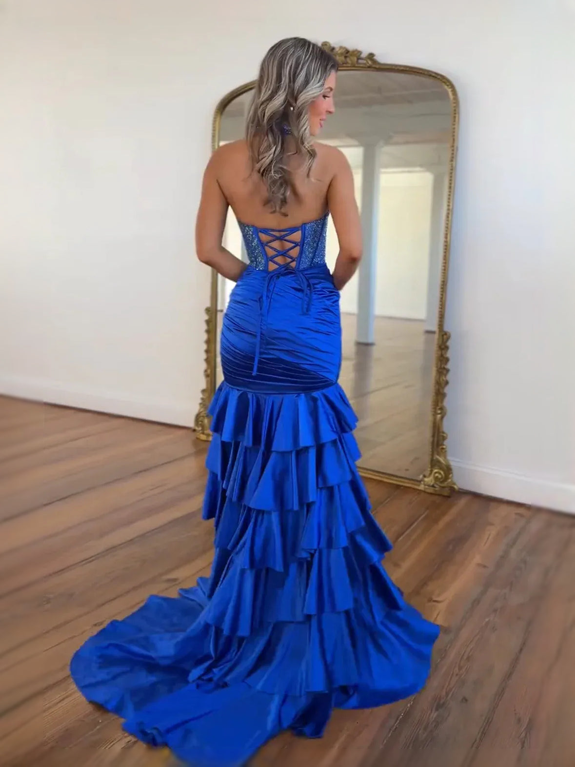 Cobalt blue corset-style mermaid prom dress with ruffled layers and halter straps