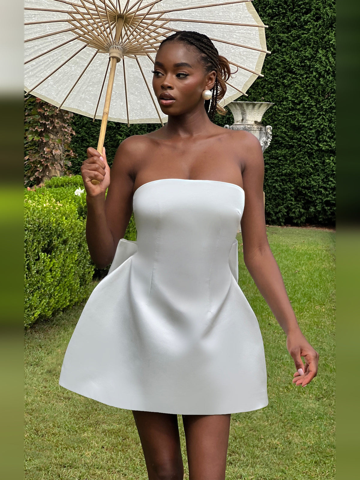 Ivory mini strapless dress with fitted bodice and flared skirt, side view.
