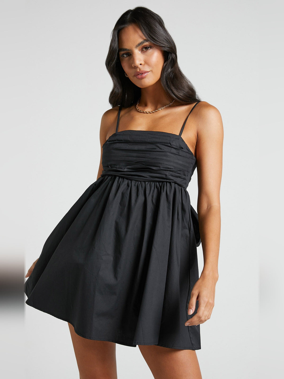 Black mini homecoming dress with spaghetti straps and ruched bodice