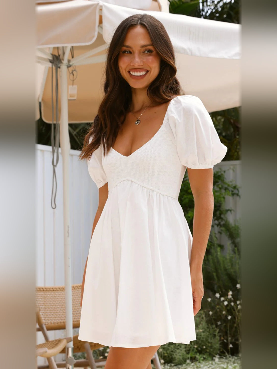 White mini homecoming dress with V-neck, puff sleeves, and gathered waist