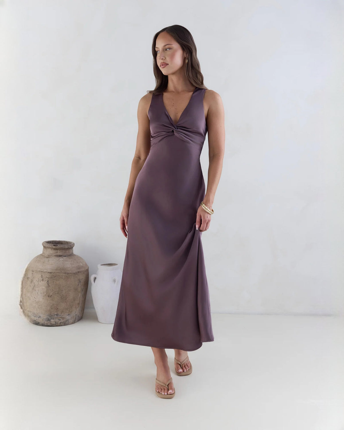 Purple satin sleeveless maxi dress with knot front and A-line skirt.
