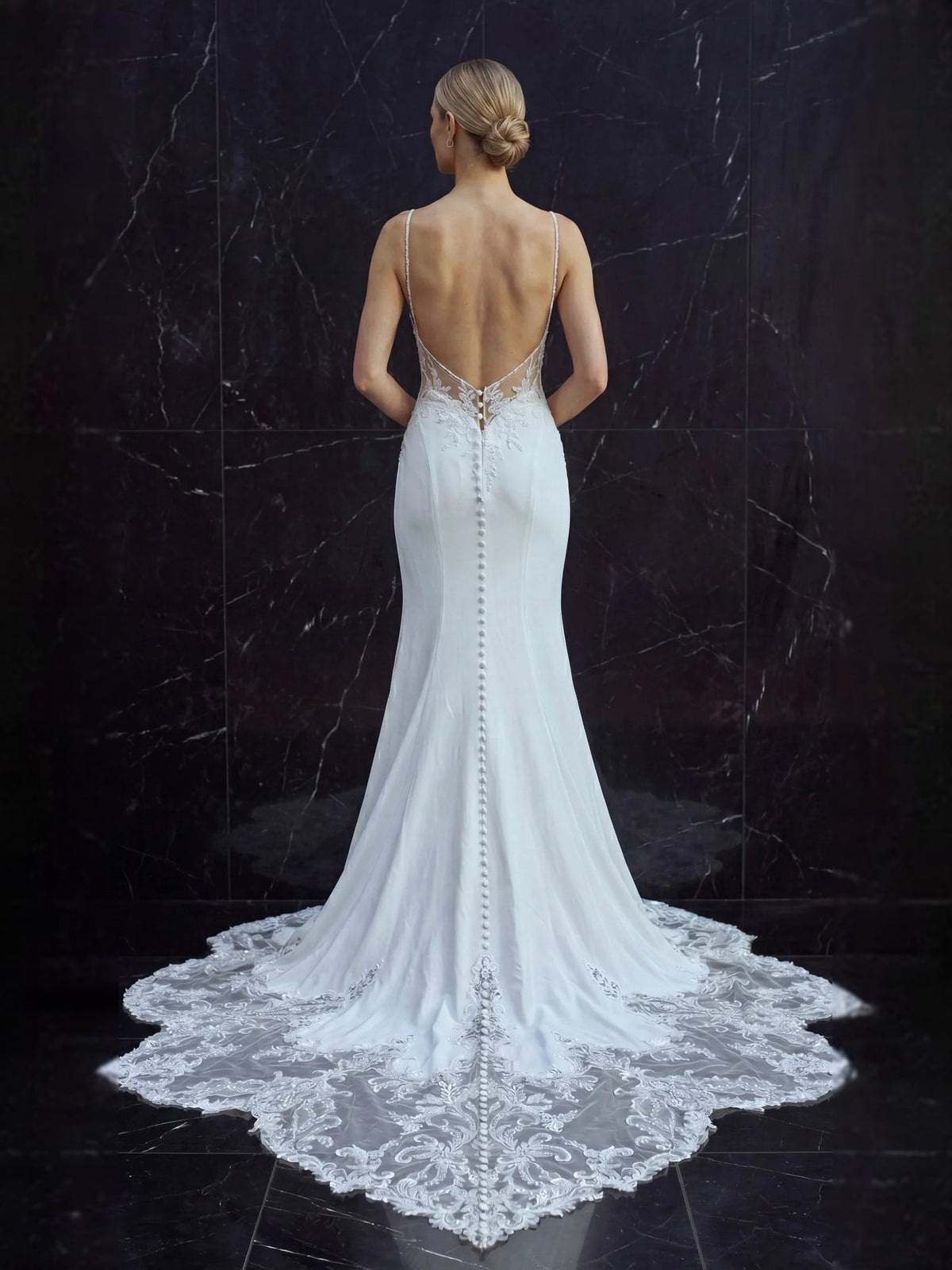 White lace mermaid wedding dress with V-back, thin straps, and floor-length train