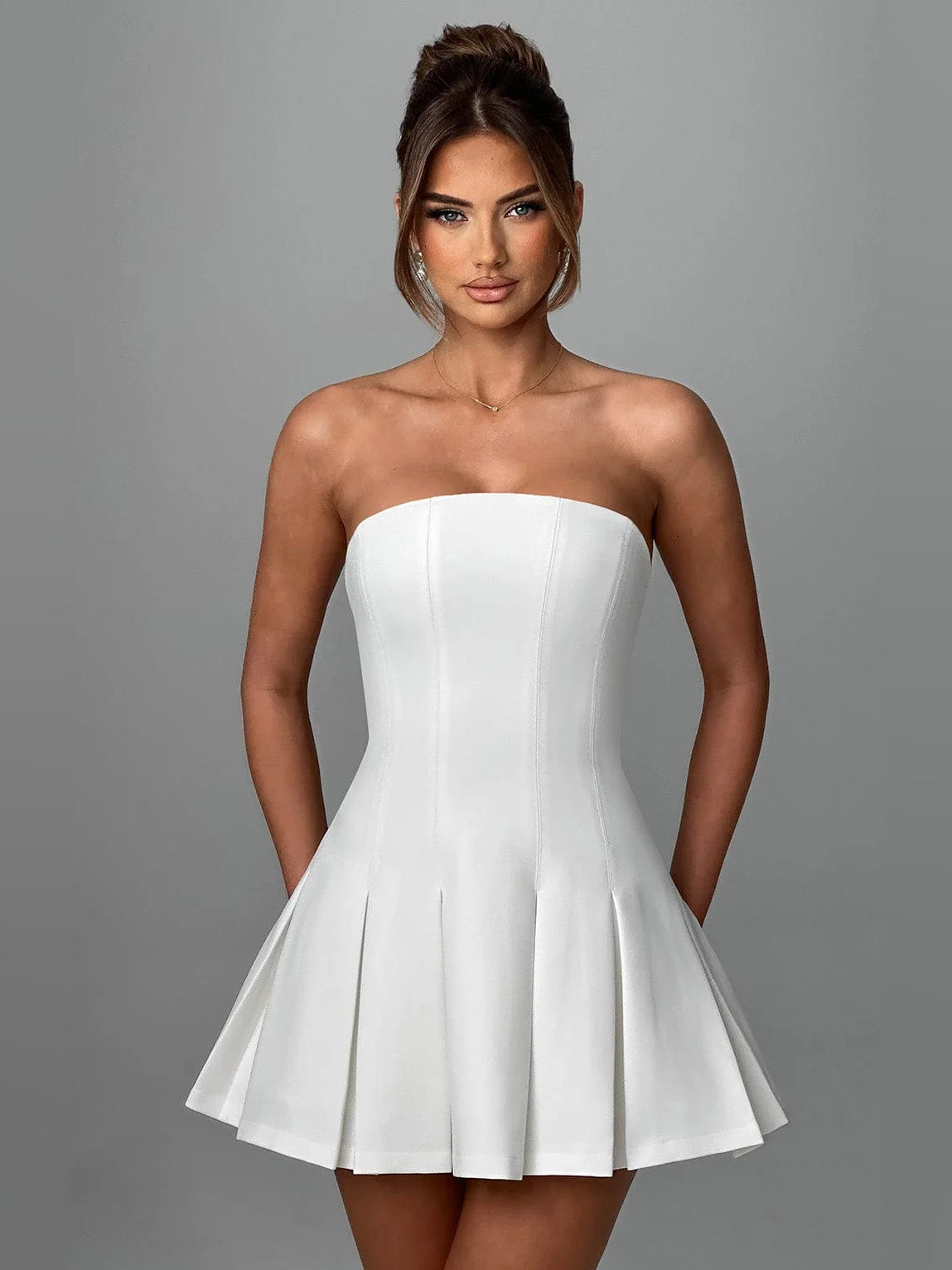 Ivory strapless mini homecoming dress with fitted bodice and pleated flared skirt