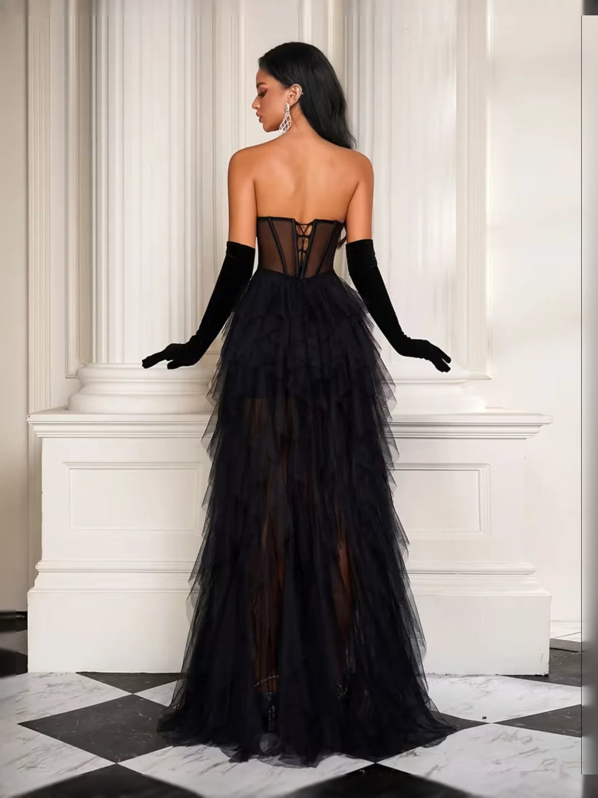 Black strapless corset prom dress with tiered tulle skirt and slit hem, long sheer gloves