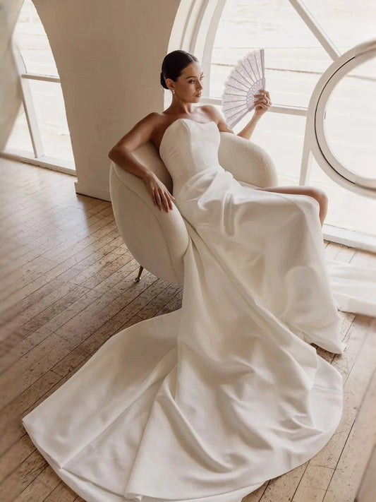 Ivory satin strapless sweetheart corset ballgown with flowing drape and full skirt