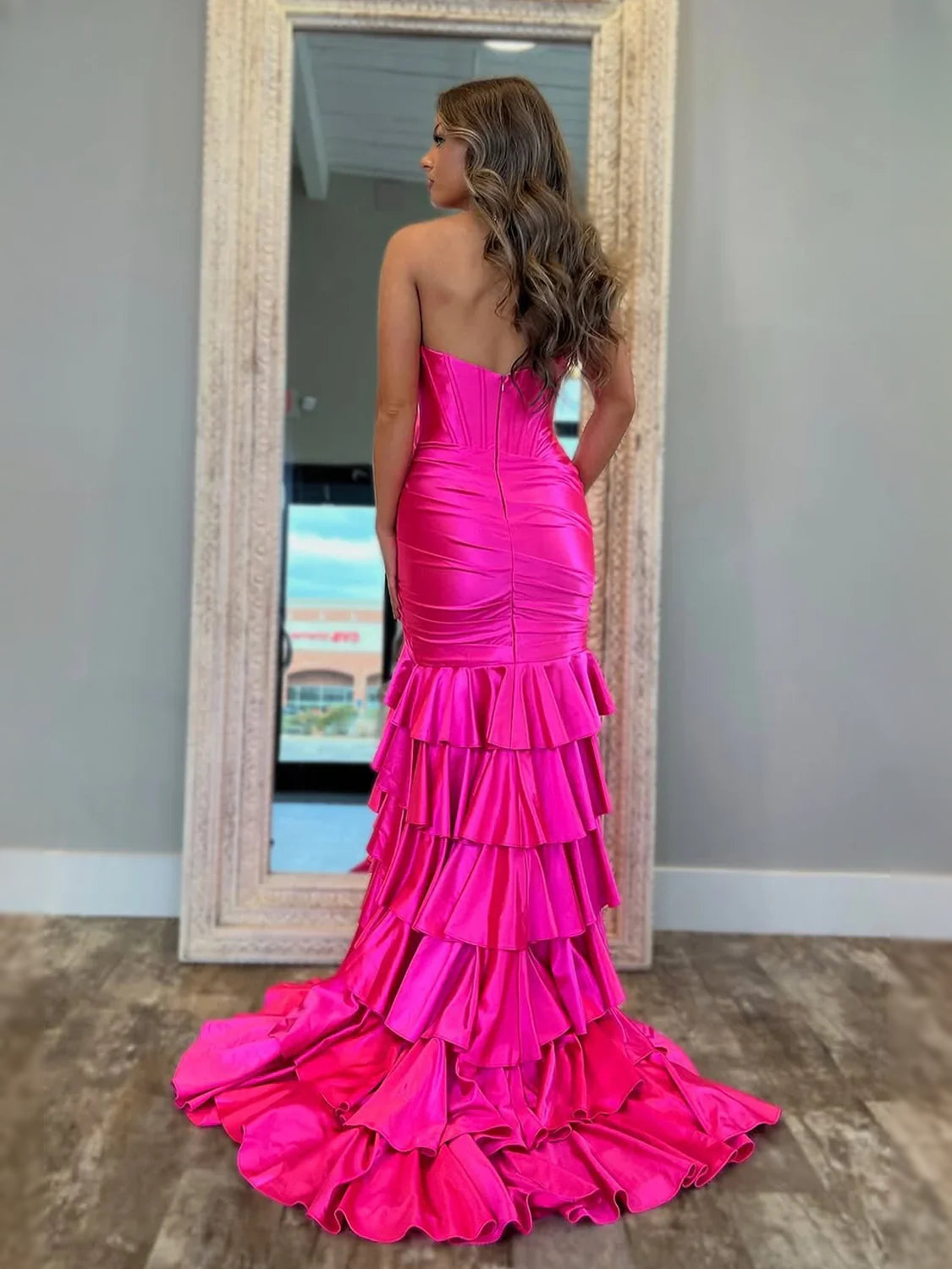 Fuchsia strapless satin corset gown with ruched bodice and tiered ruffle skirt