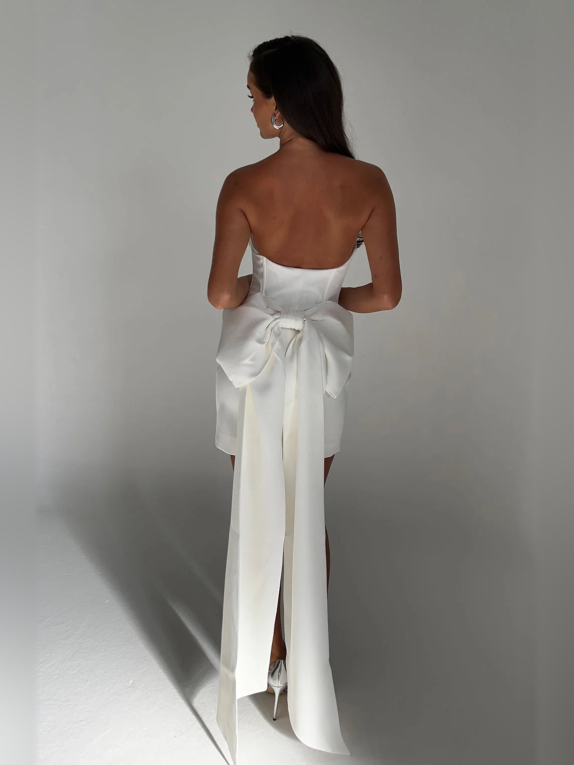 White strapless mini dress with sweetheart neckline and long bow back sash