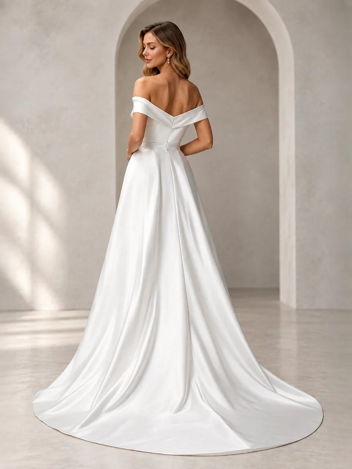 Ivory off-shoulder pleated wedding dress with draped bodice and flowing floor-length skirt