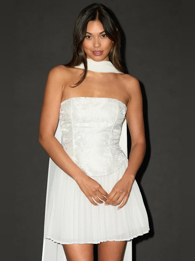 White mini dress with strapless floral bodice, pleated skirt, and choker neckline