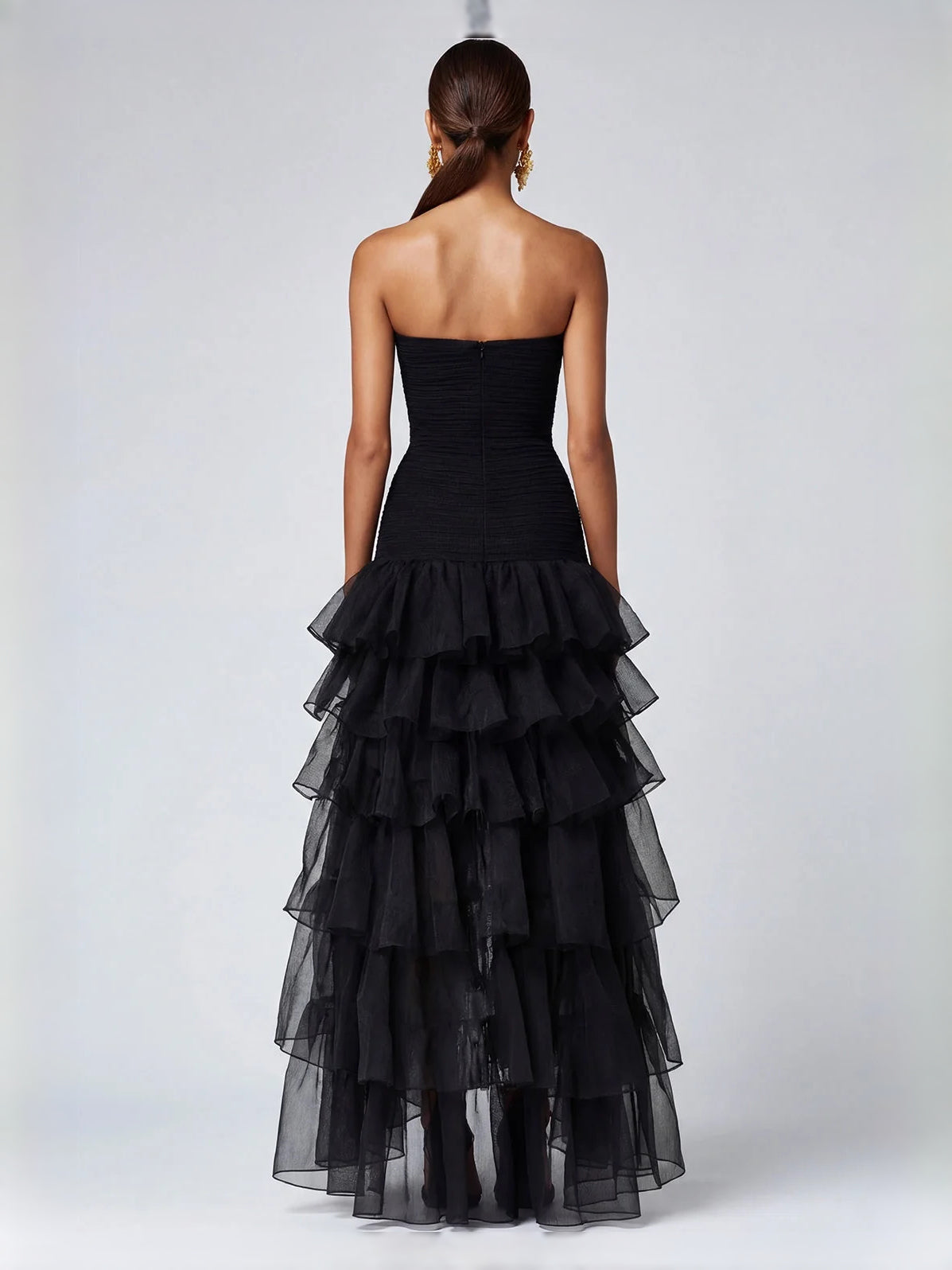 Black strapless high-low prom dress with ruched bodice and tiered ruffle skirt