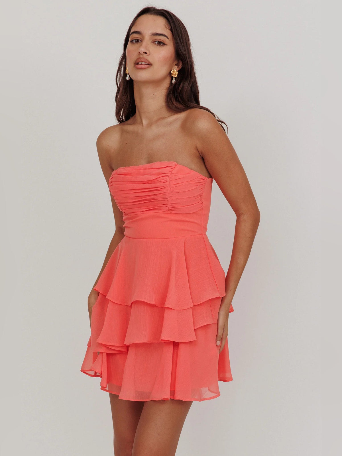 Coral strapless mini dress with ruched bodice and layered ruffle skirt