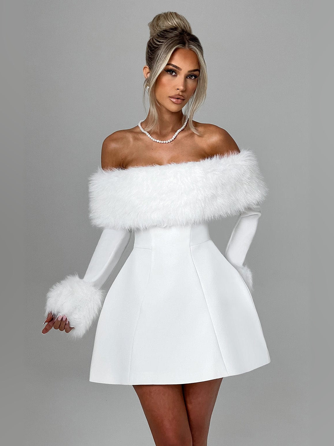 Ivory mini dress with off-shoulder faux fur trim and fitted bodice, short skirt.