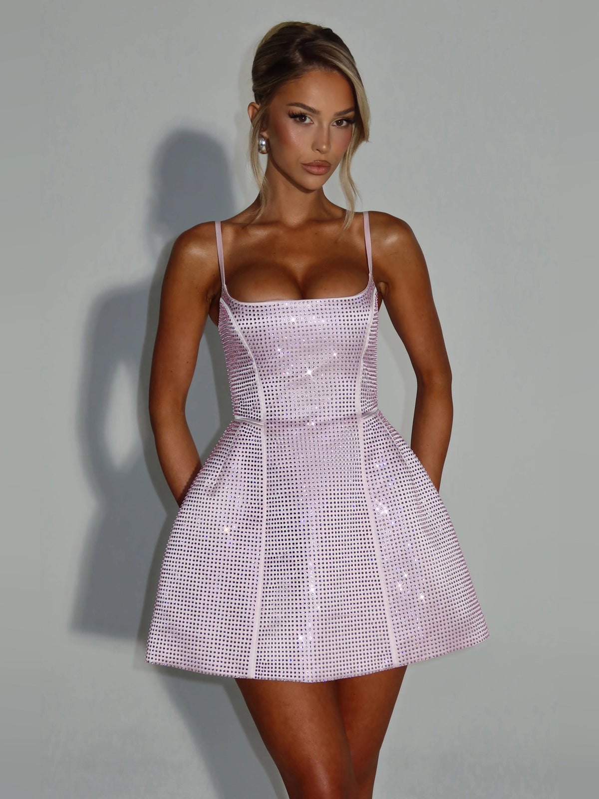 Blush mini homecoming dress with thin spaghetti straps and sparkling sequin bodice