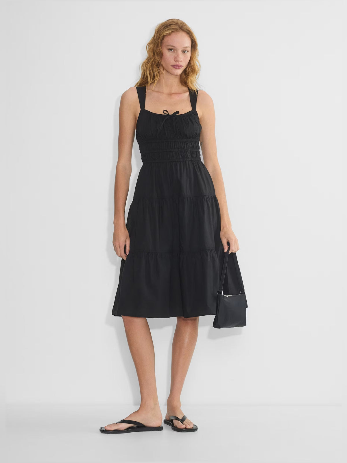 Black tiered midi dress with spaghetti straps, square neck, bow detail, smocked bodice
