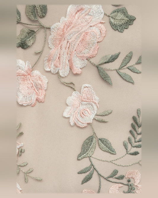 Beige fabric with embroidered peach flowers and green leaf accents