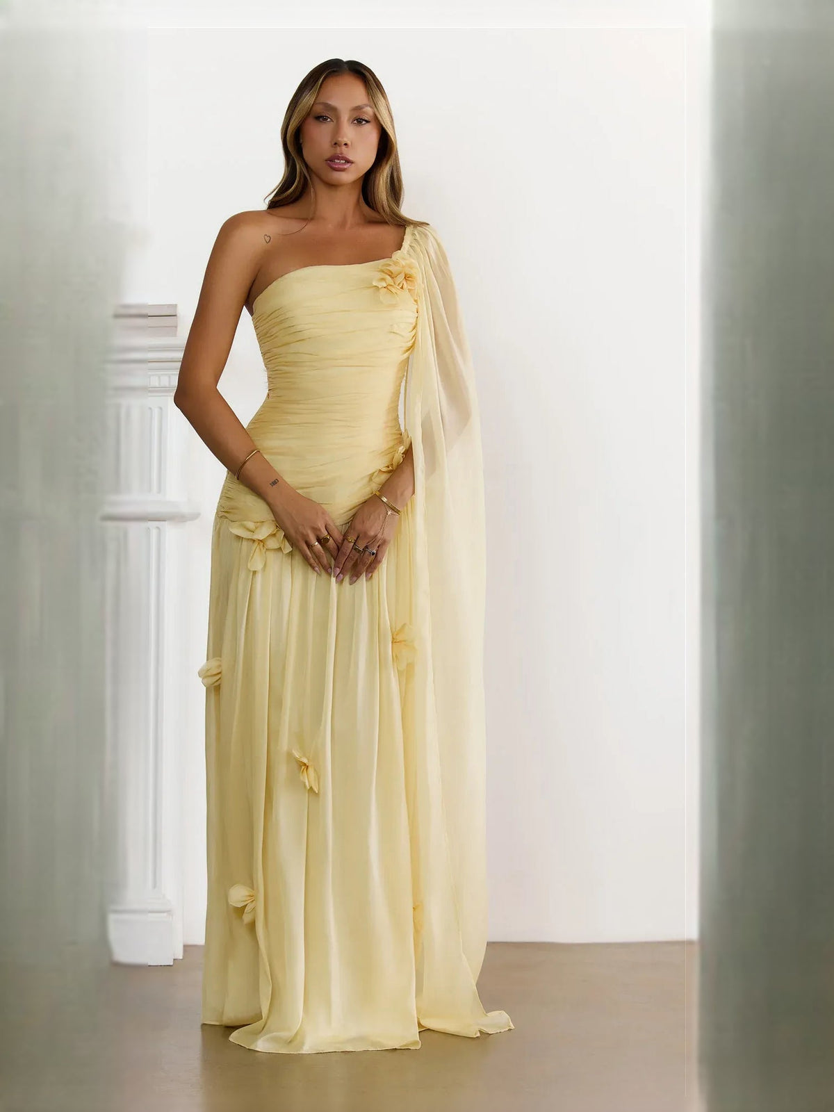 Ruched one-shoulder maxi dress in pale yellow with draped tulle overlay and floral detail