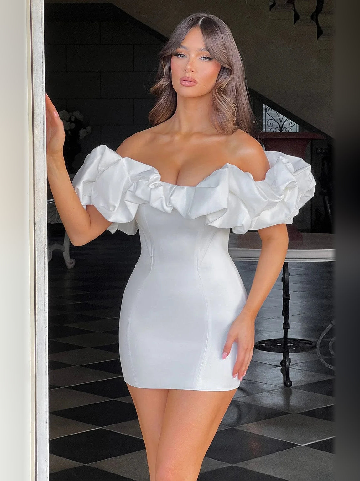 White off-shoulder mini dress with voluminous ruffle sleeves and fitted bodice