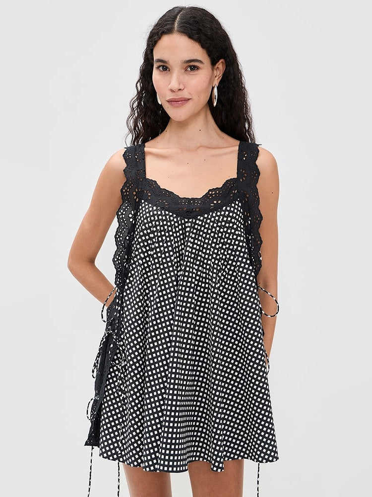 Black mini dress with white dotted grid print, lace-trim square neckline, sleeveless