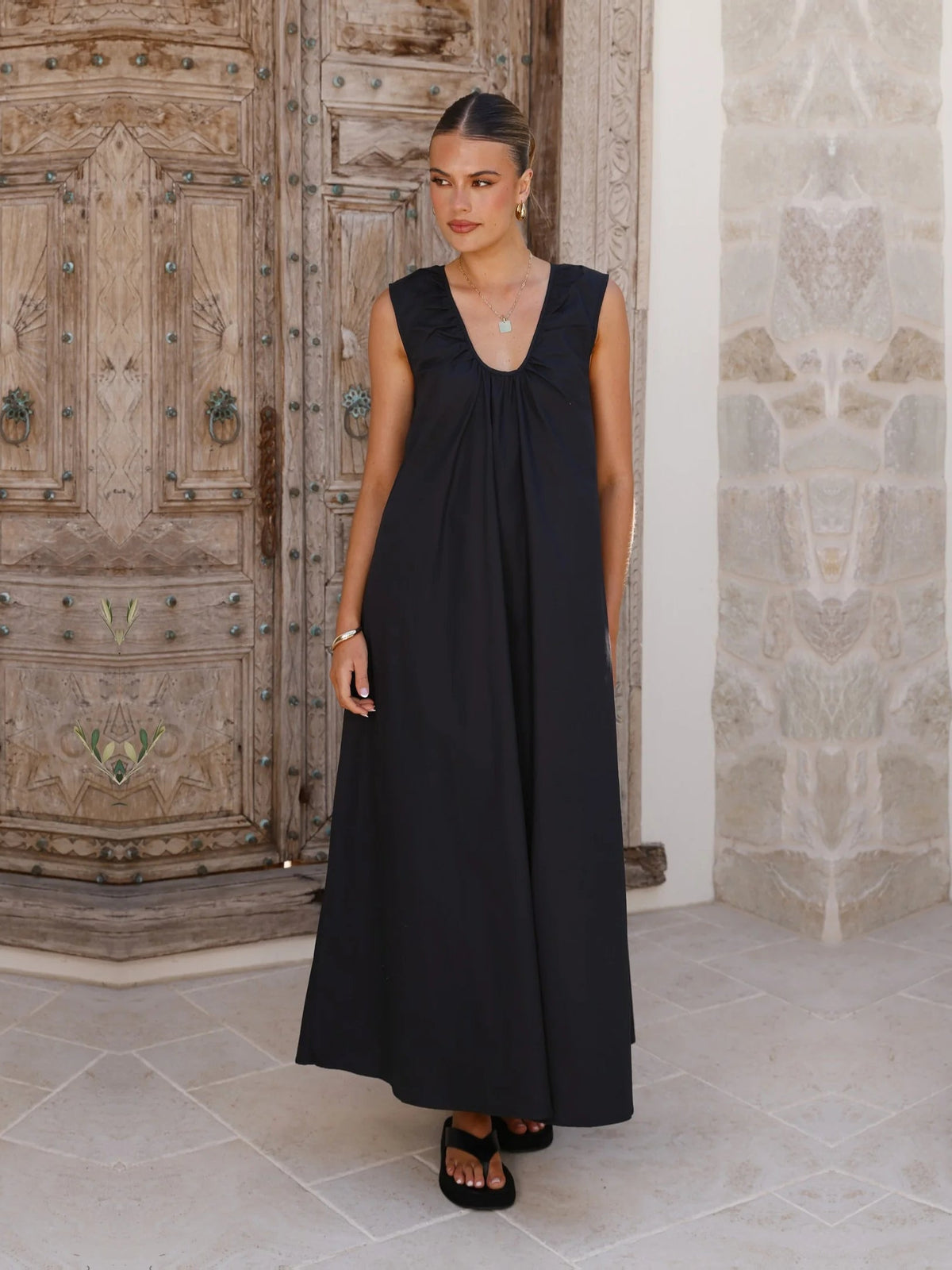 Black a-line maxi formal dress with halter neckline, full-length front view