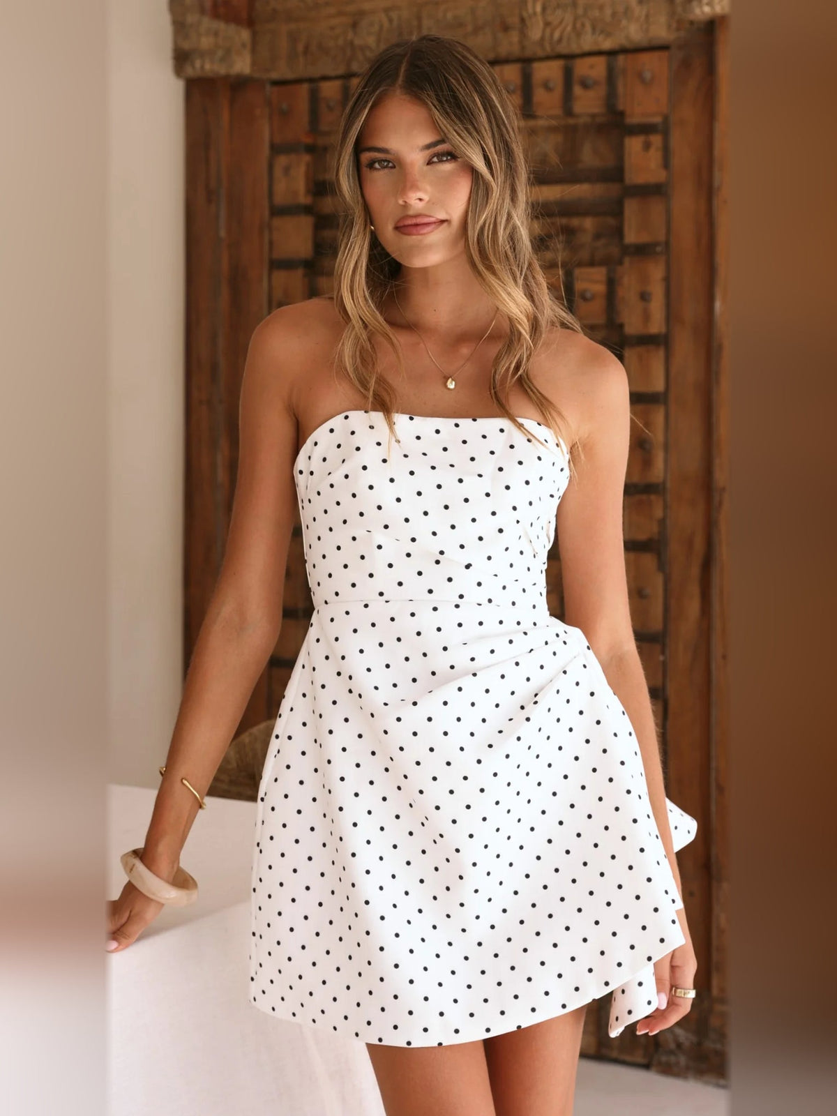 White mini homecoming dress with black polka dots, strapless sweetheart neckline