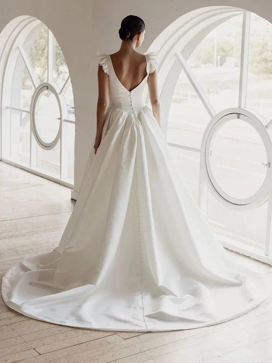 Ivory satin ball-gown wedding dress with draped corset, ruffled cap sleeves, V-back