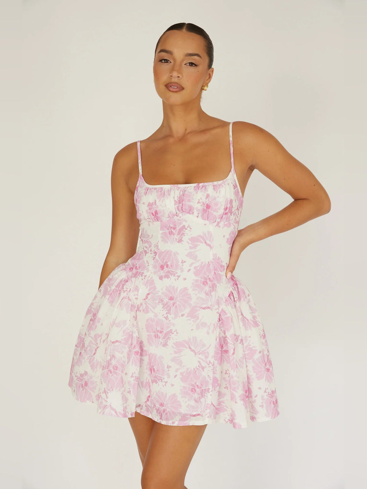 Pink floral mini dress with spaghetti straps and flared tiered skirt