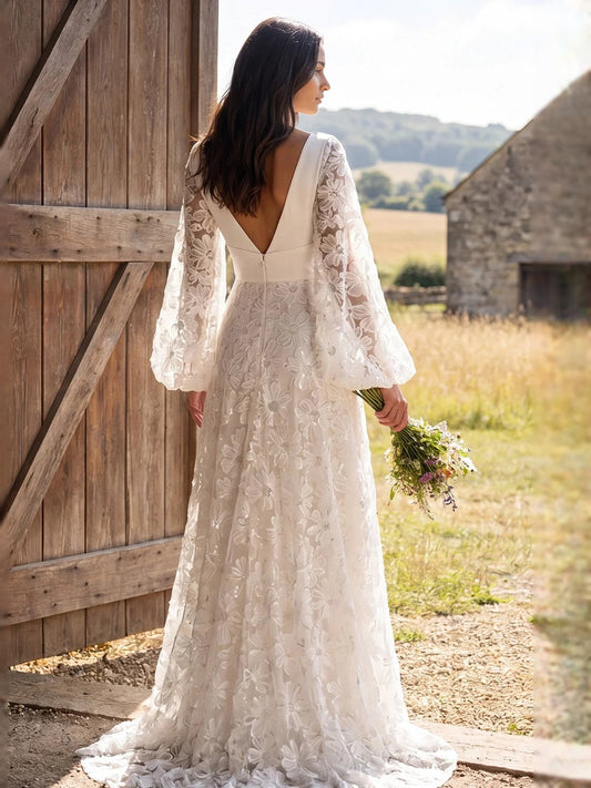 Ivory floor-length lace wedding dress with deep V back and long sheer floral sleeves