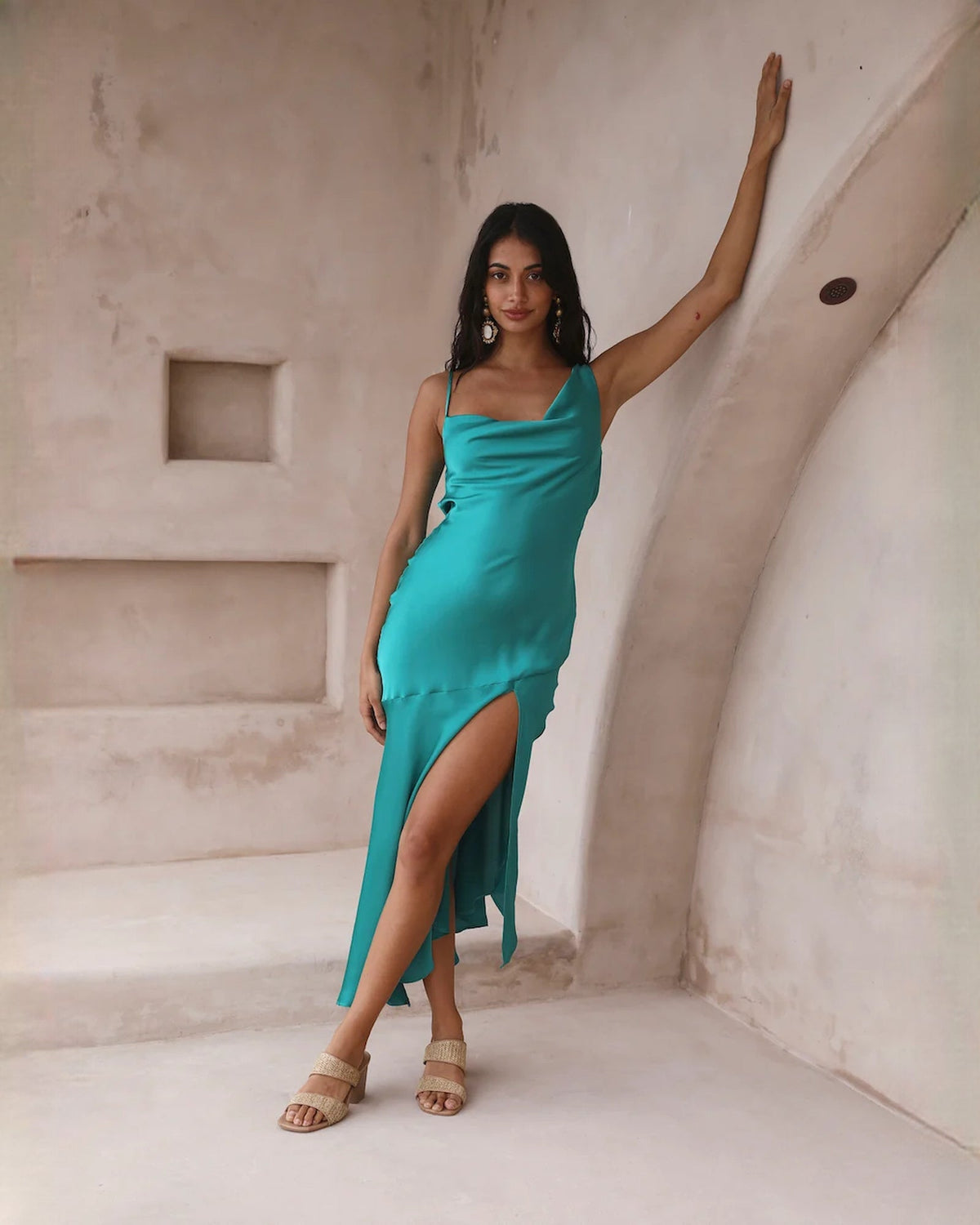 Teal satin sleeveless A-line midi dress with cowl neckline and side slit.