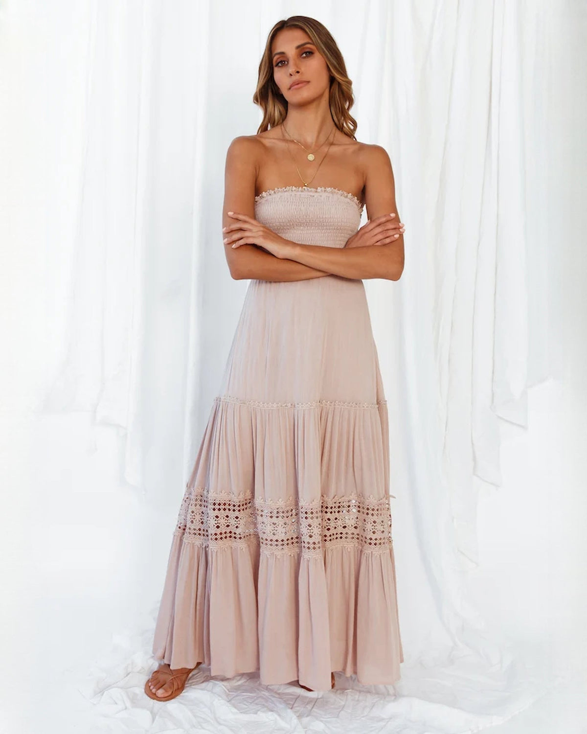 Blush pink tiered maxi bridesmaid dress with smocked bodice and lace-trim hem