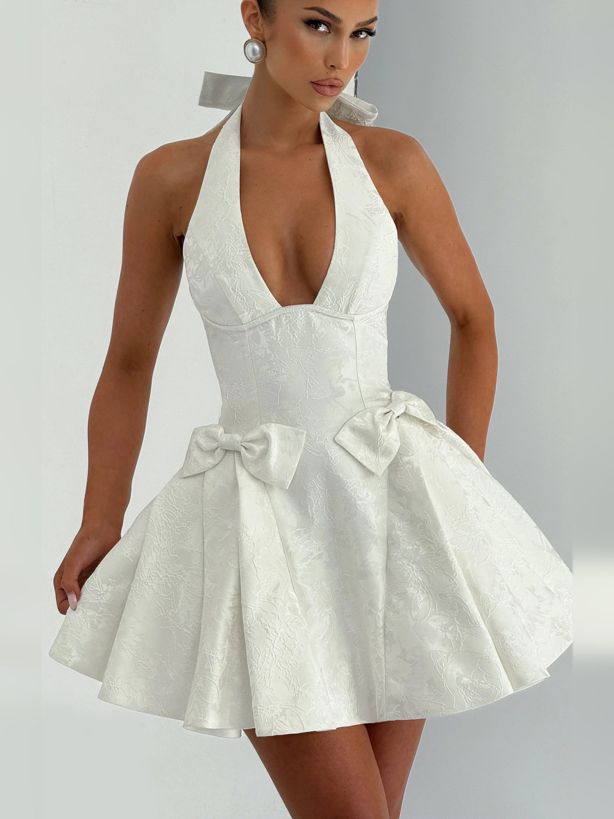 Ivory halter mini homecoming dress with bow at waist and flared skirt