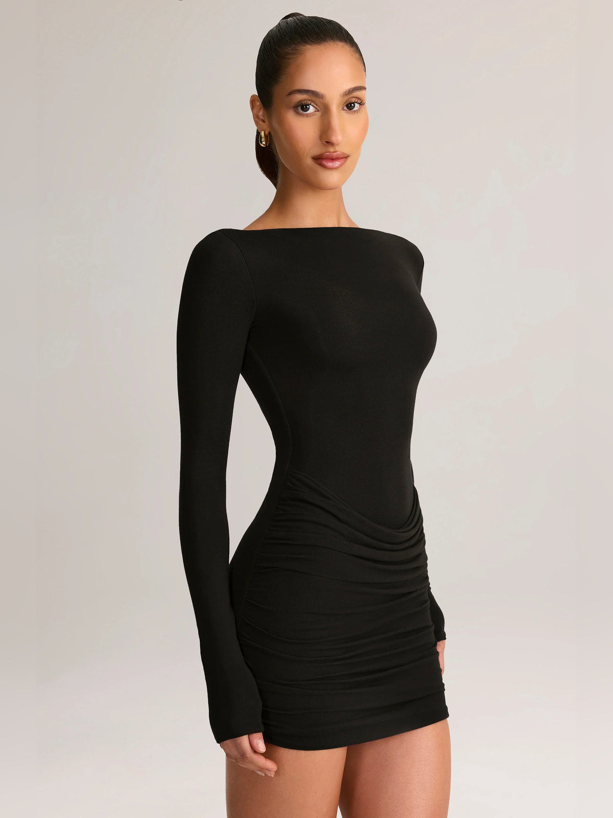 Black draped boat-neck mini homecoming dress with long sleeves, ruching at waist