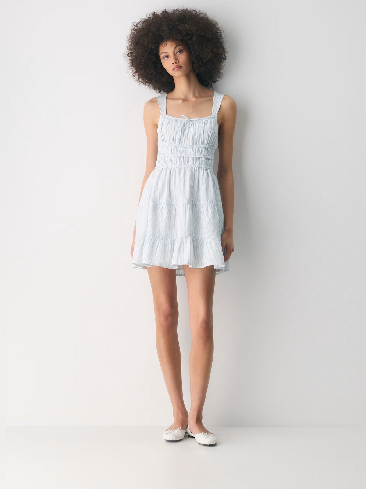 White tiered mini dress with thin straps and square neckline