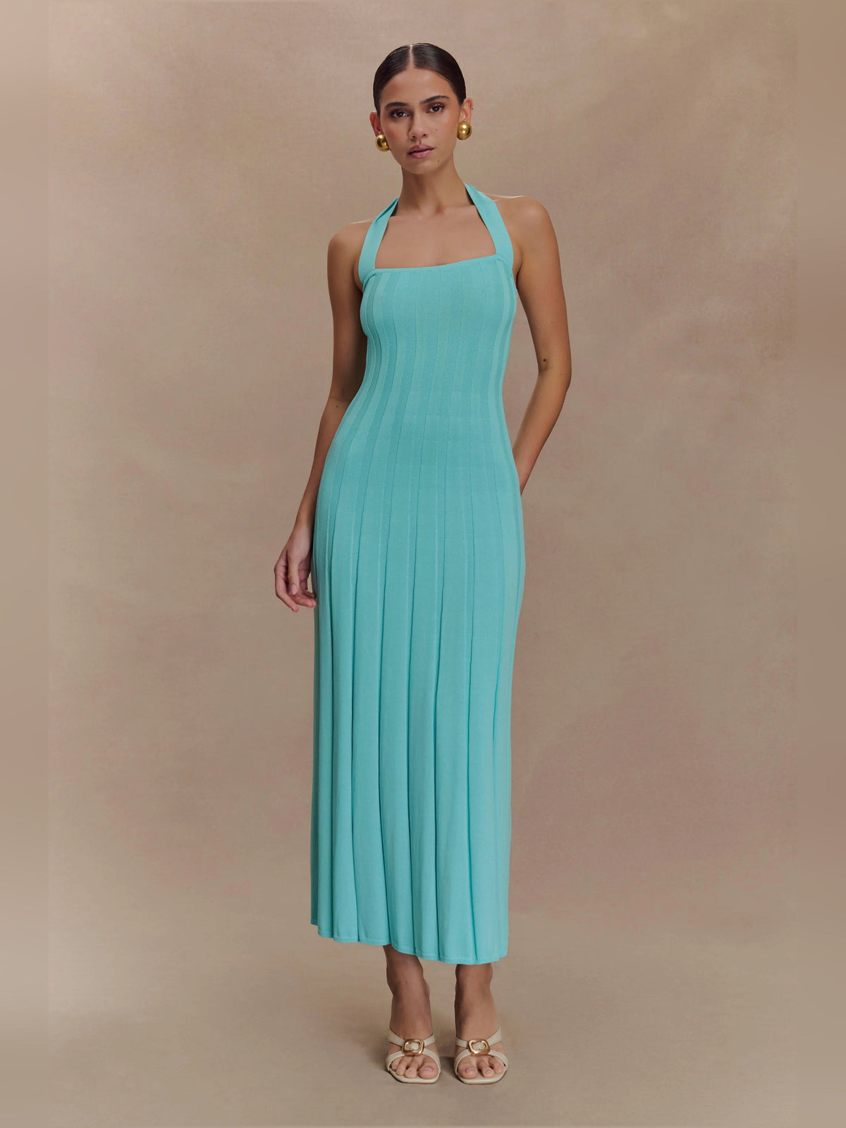 Turquoise halter knit midi dress with vertical rib texture, fitted bodice and pleated skirt