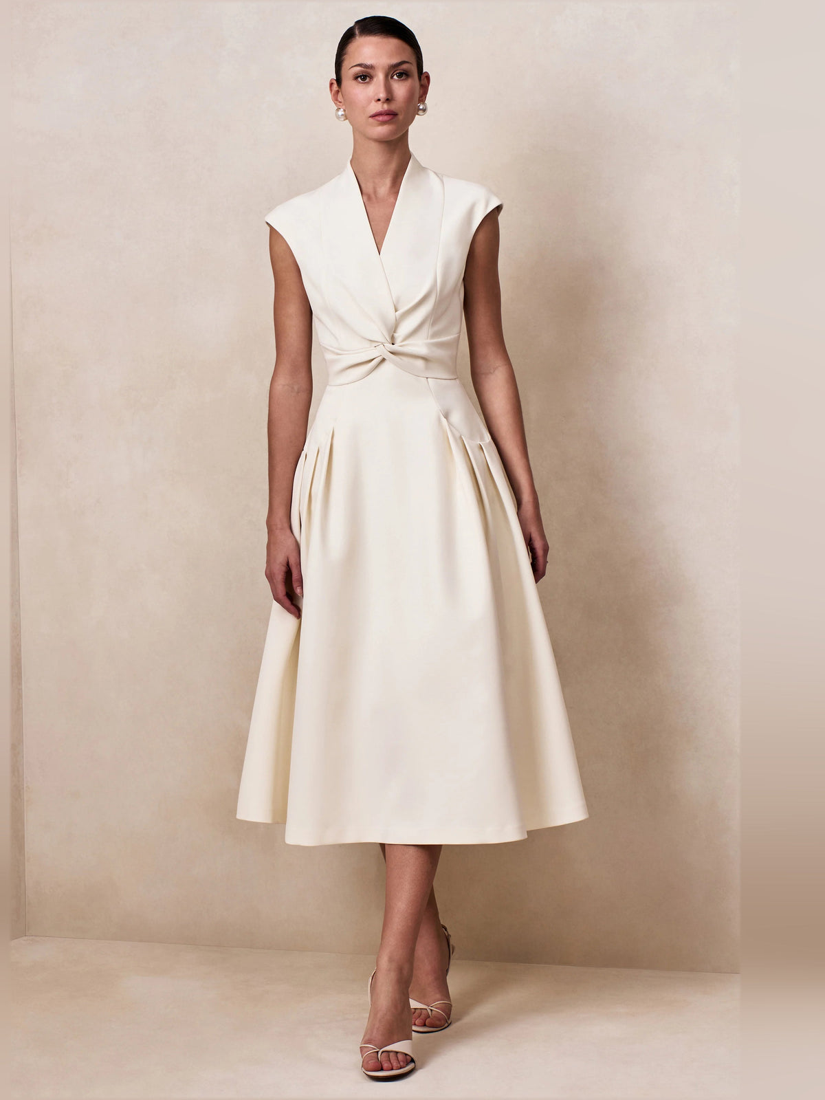 Cream V-neck sleeveless midi dress with twisted waist and full skirt