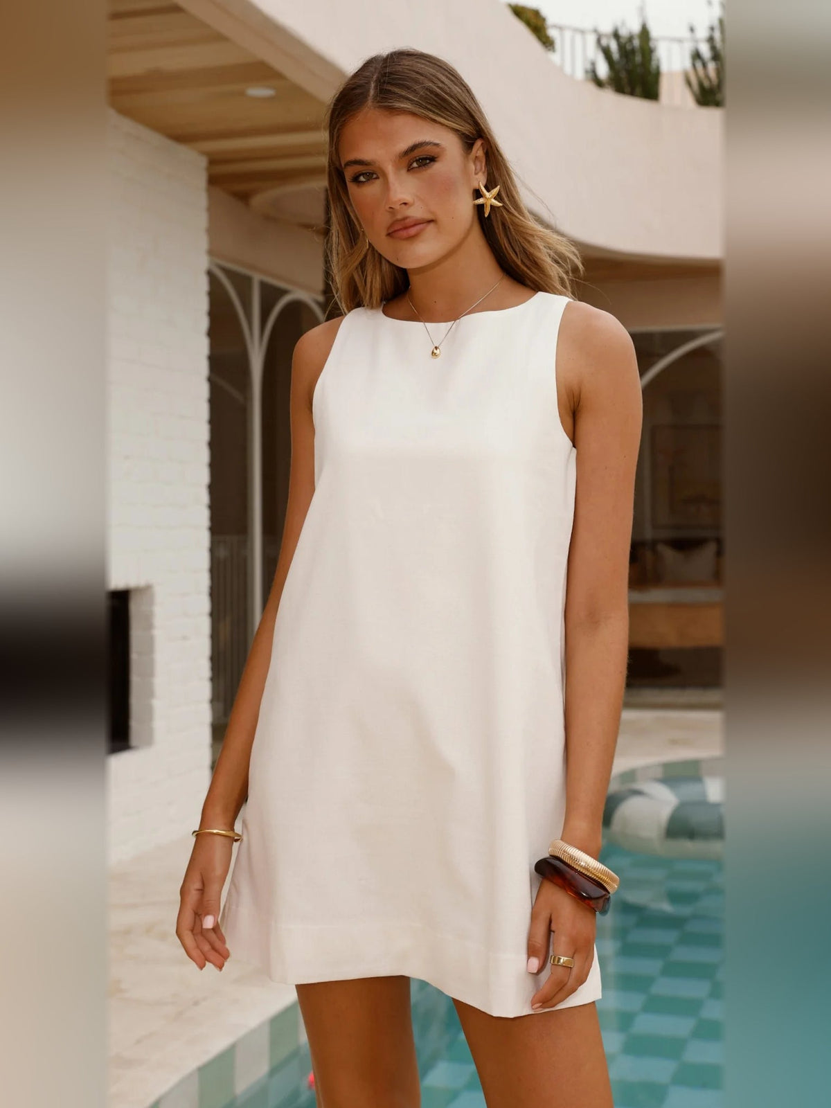 White sleeveless mini shift dress with crew neckline and straight above-knee hem