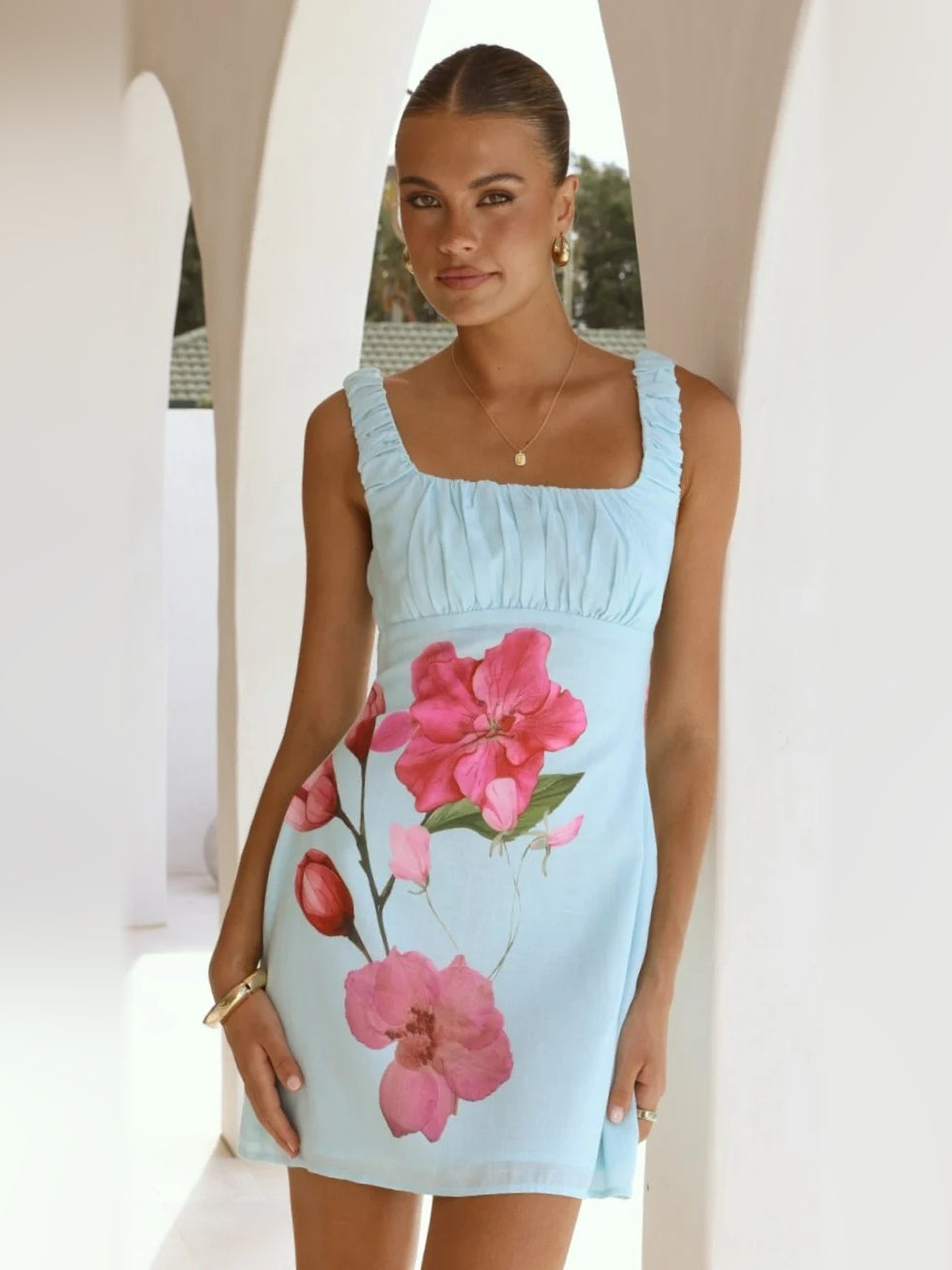 Light blue floral mini dress with square neckline, ruched bodice, ruffle sleeves