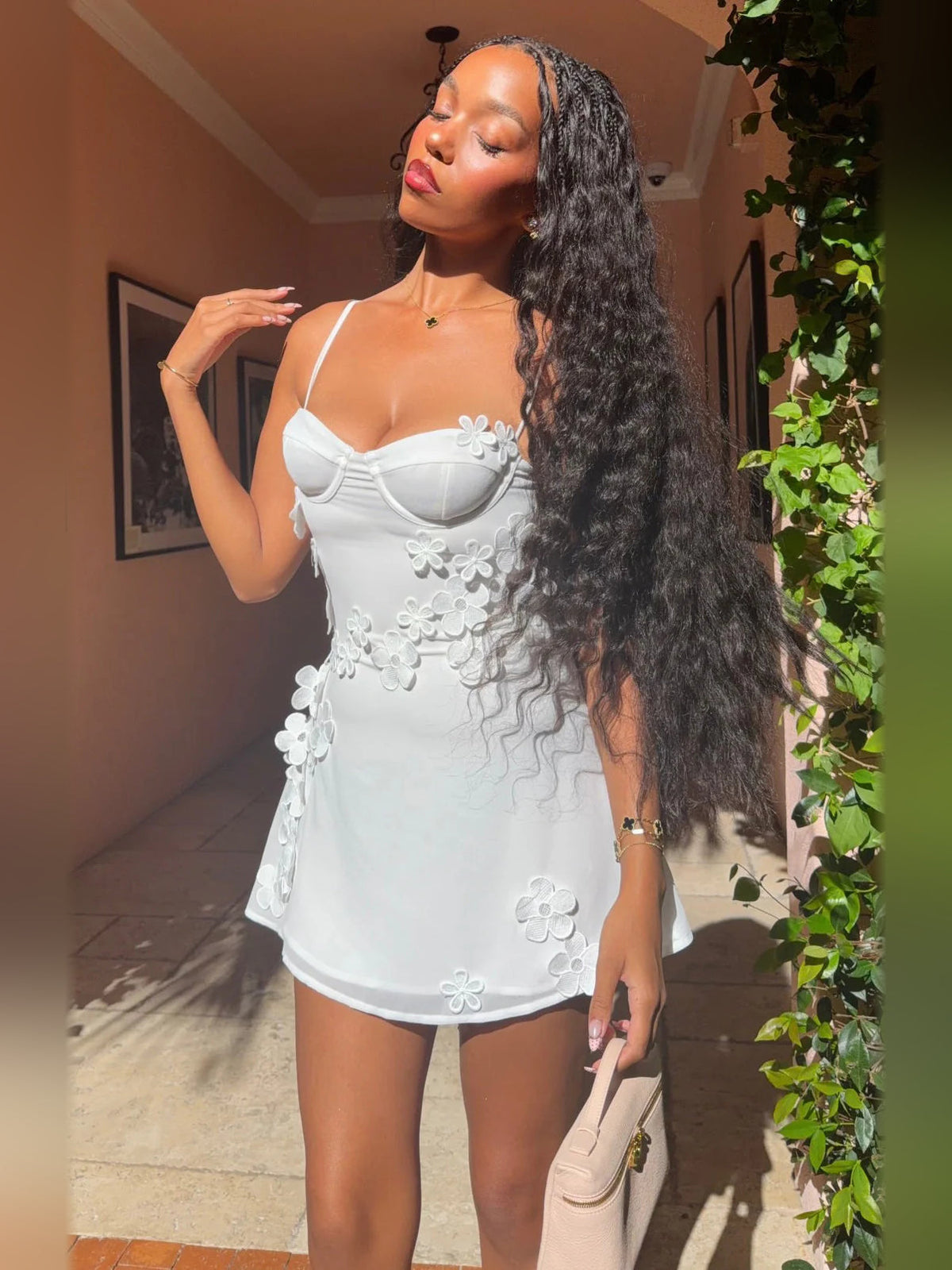White mini dress with spaghetti straps and floral appliqué detail