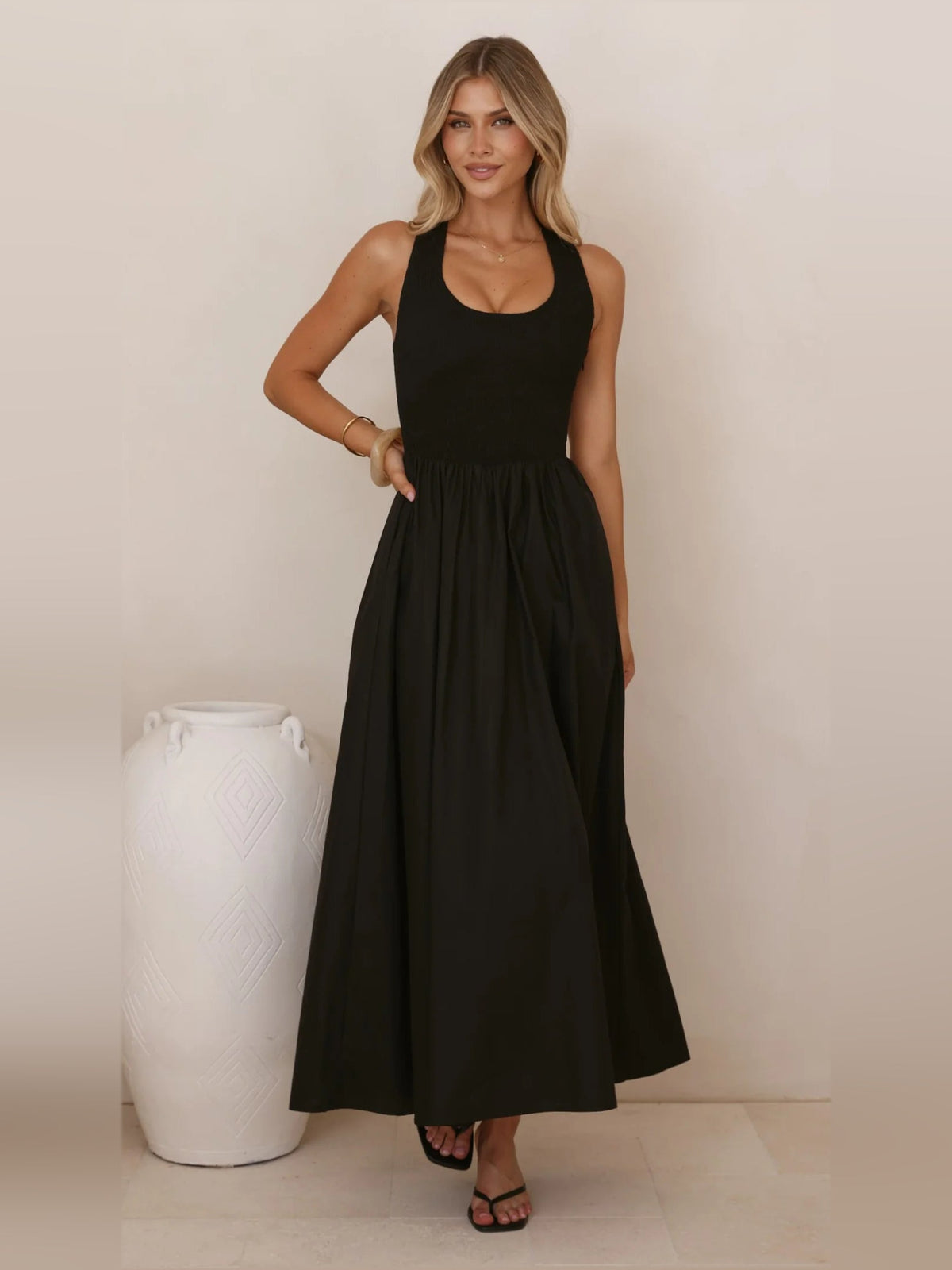 Black a-line maxi formal dress with halter neckline, full-length front view