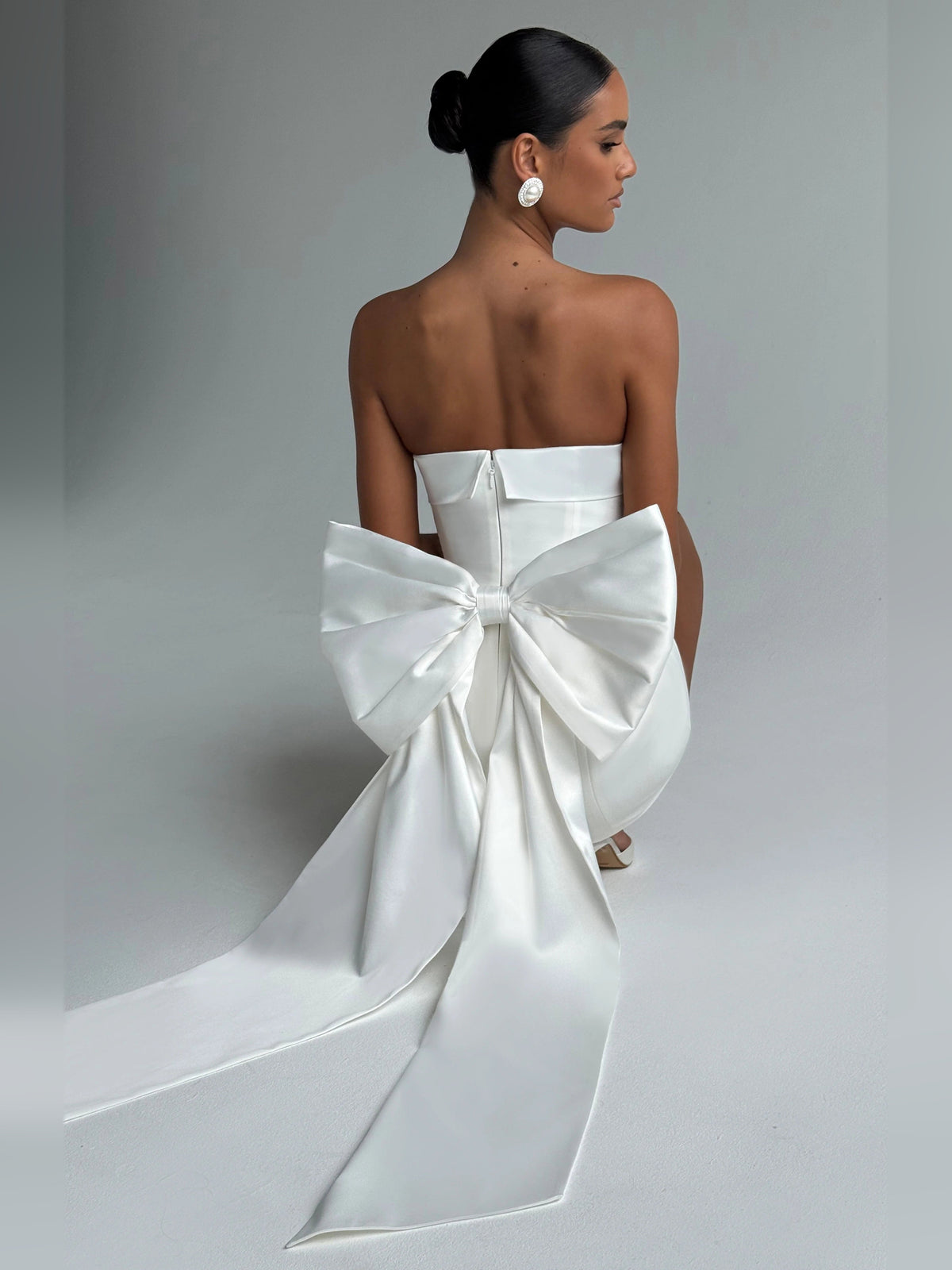 Ivory strapless mini dress, ruched back with large bow detail