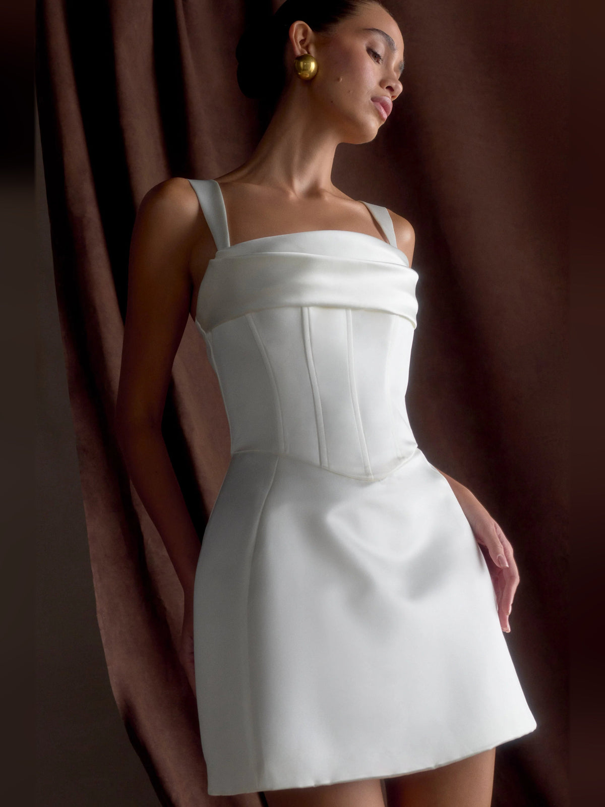 White satin corset mini dress with square neckline and spaghetti straps, side profile