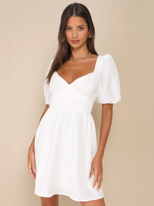 White v-neck wrap mini dress with short puff sleeves, gathered waist
