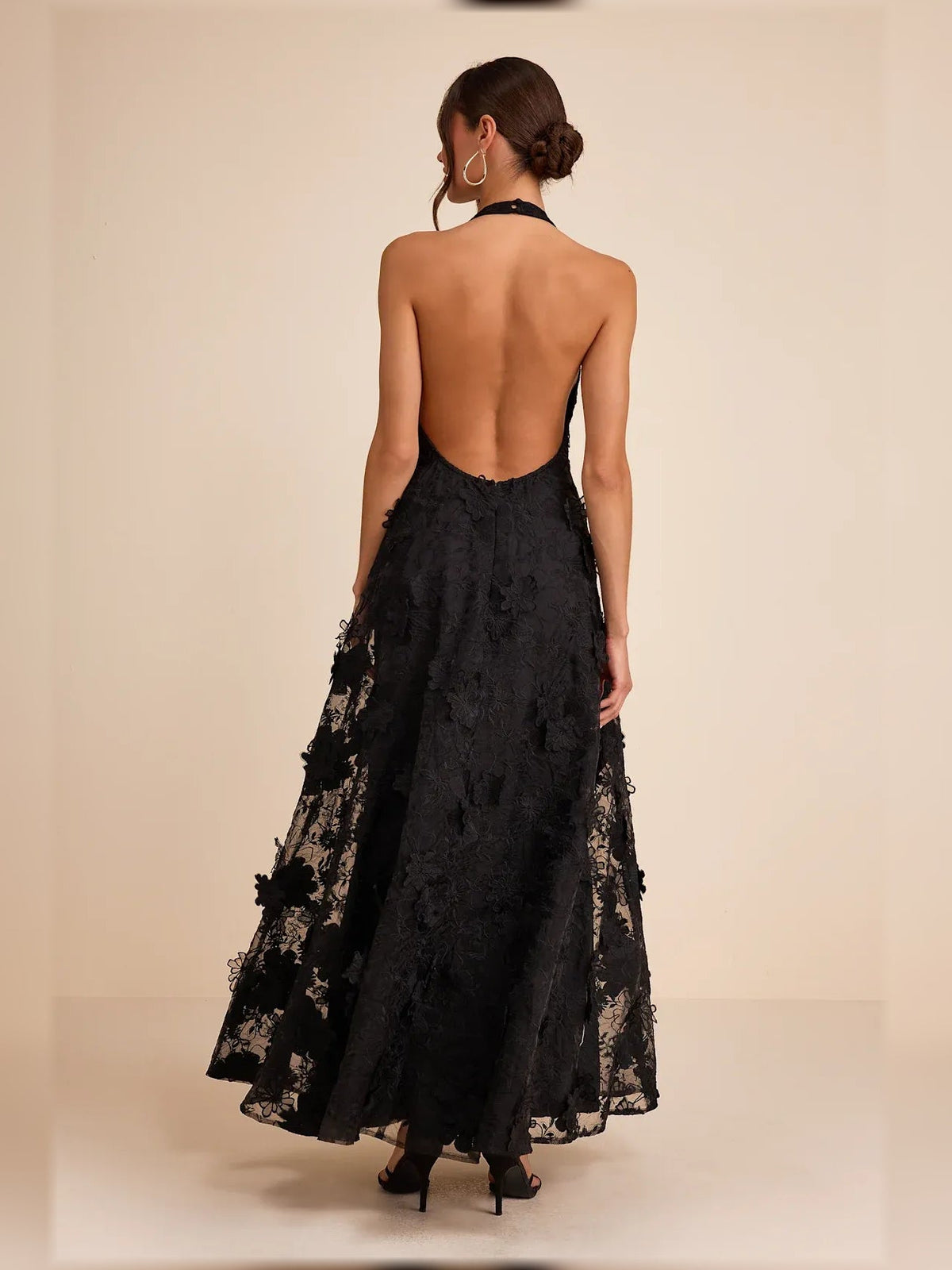 Black halter maxi dress from back view with open back and floral lace appliques