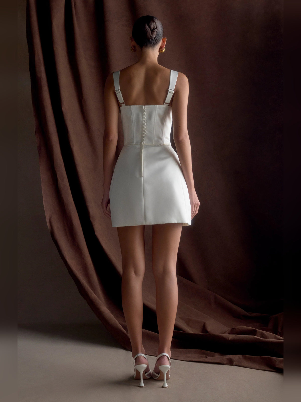 White satin corset mini dress with thin straps, back view and fitted skirt